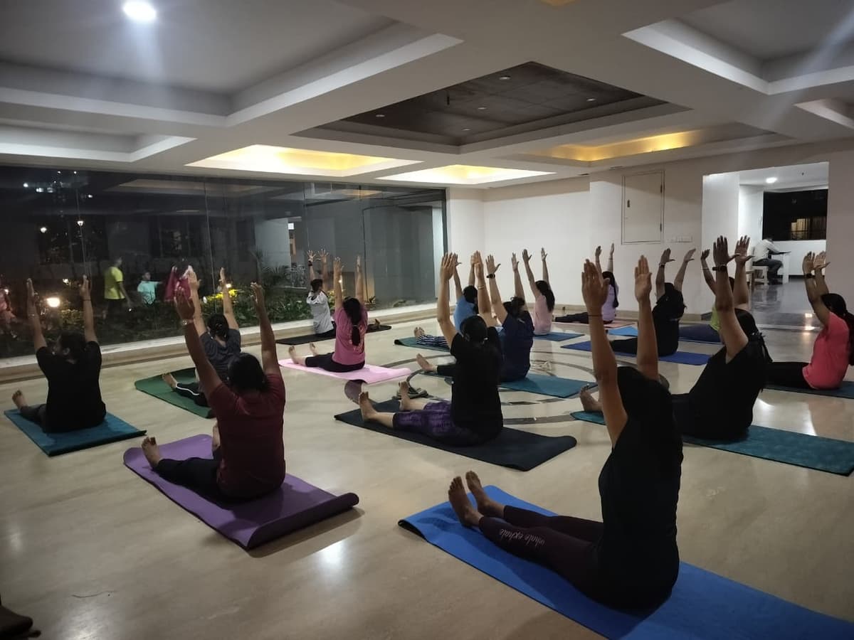 Professional yoga instructor demonstrating proper form during a group class at Fit Elite studio - certified yoga training